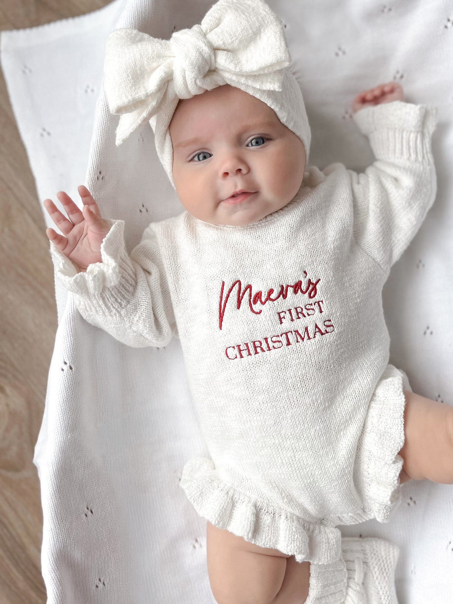 White baby romper with 'first Christmas' embroidery