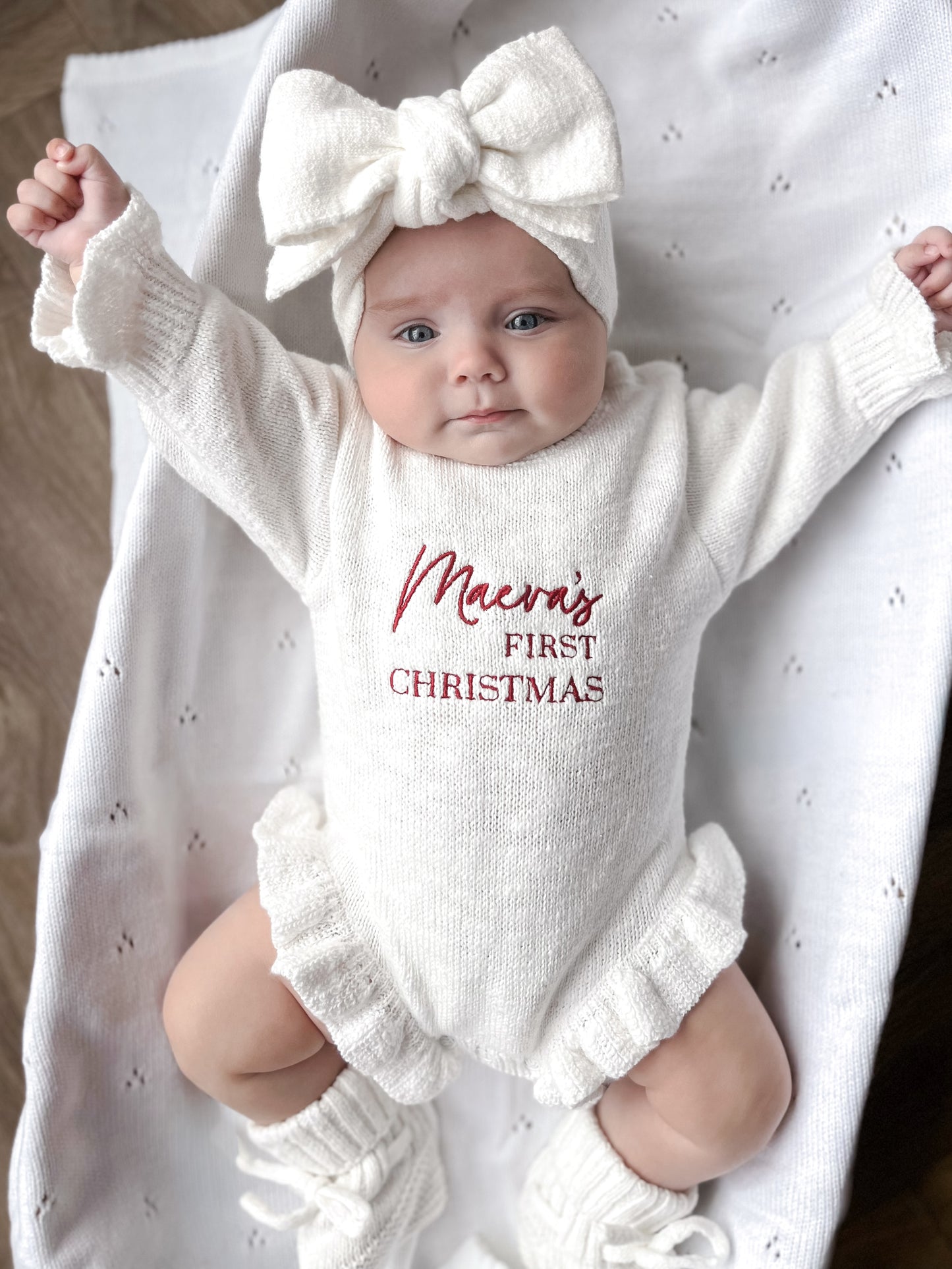 White baby romper with 'first Christmas' embroidery
