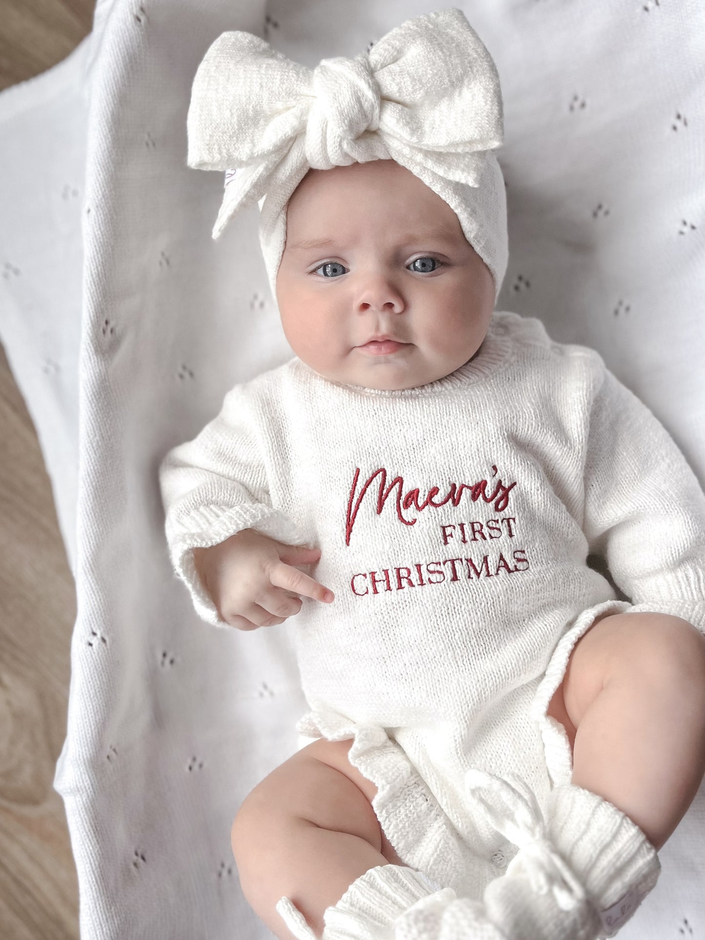 White baby romper with 'first Christmas' embroidery