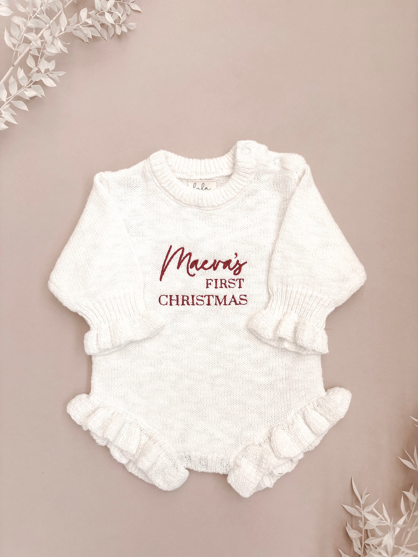 White baby romper with 'first Christmas' embroidery