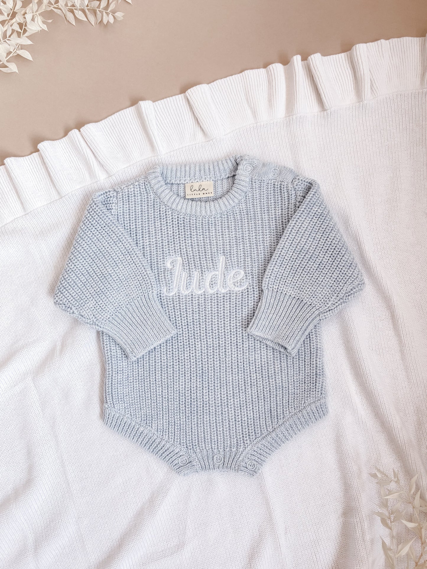 Light blue baby romper with 'Jude' embroidered in white
