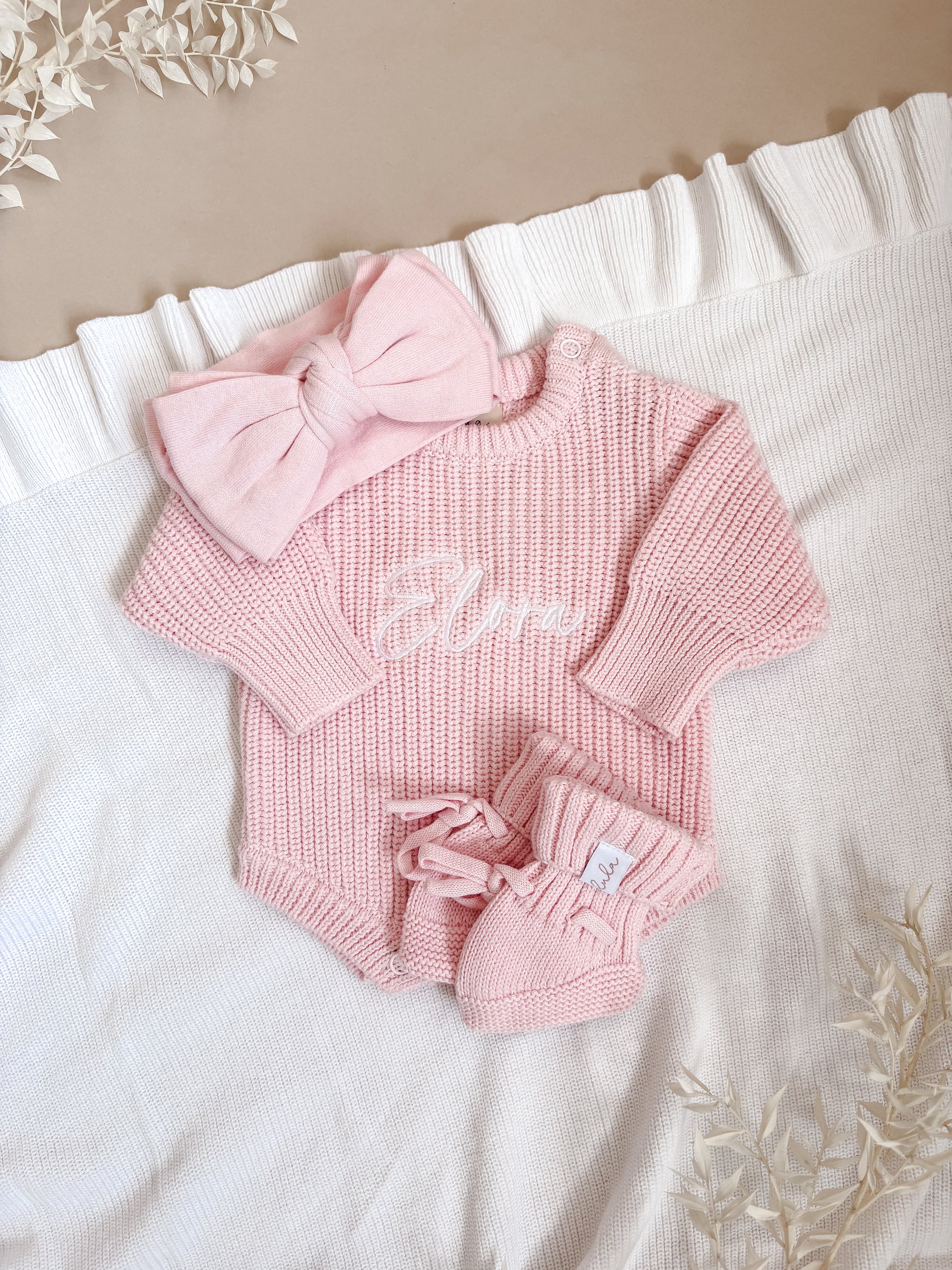 Pink chunky knit baby outfit with a bow and booties