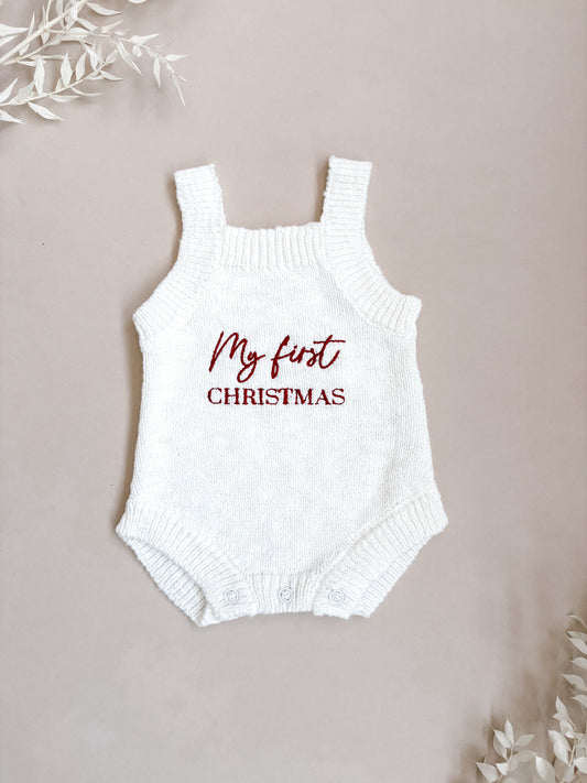 White baby romper with 'My first Christmas' text on a beige background