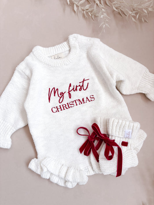 Baby outfit with 'My first Christmas' text on a beige background